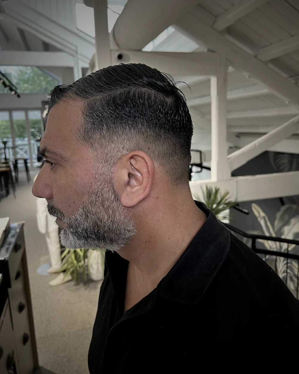 Side profile of a finished low fade with a beard