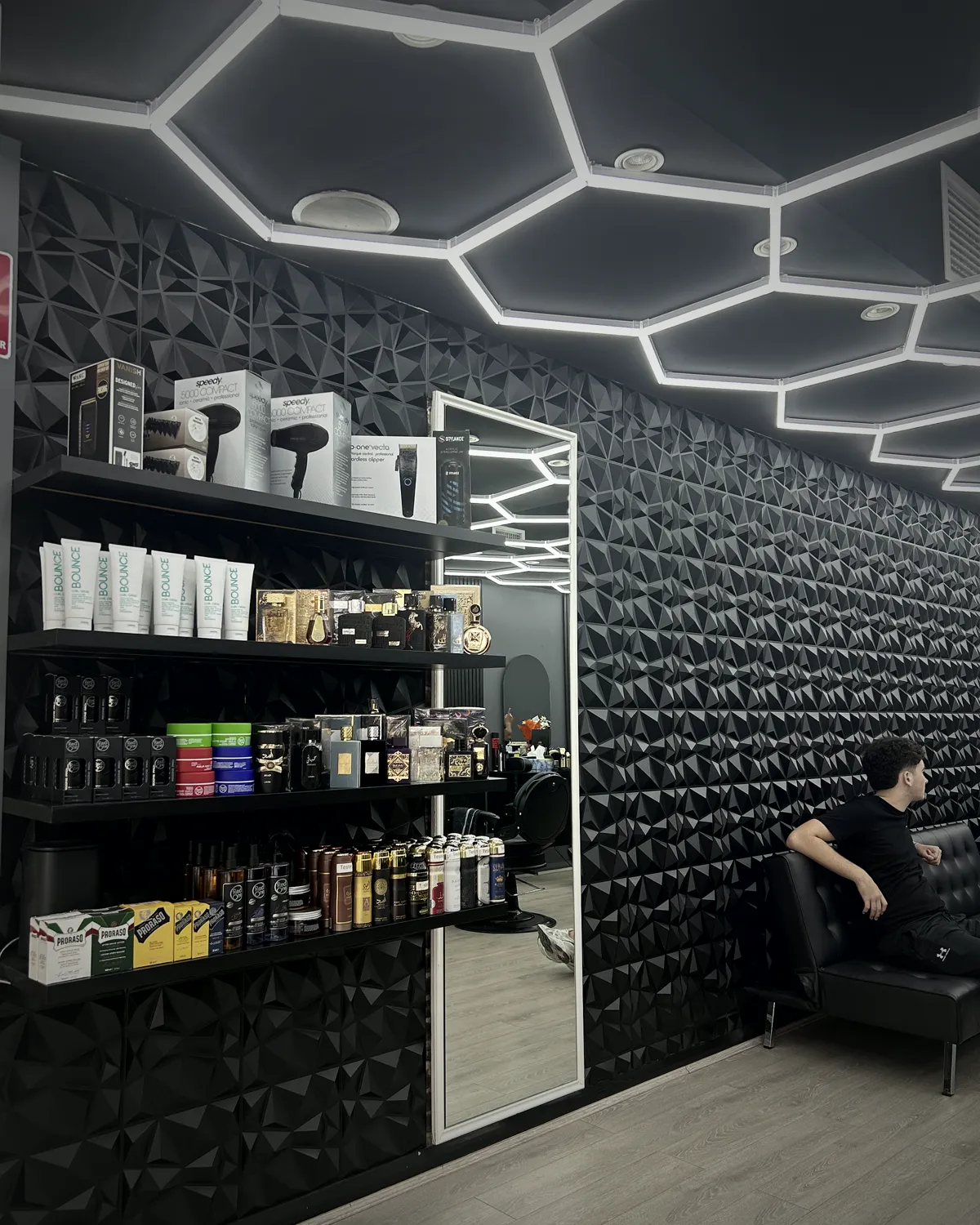 Black textured walls, product shelves and the lit hexagon ceiling